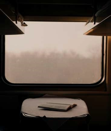 A book on a table in an empty train compartmet